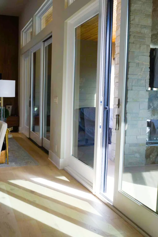 Afternoon sun streaming through untinted sliding glass doors onto a hardwood floor
